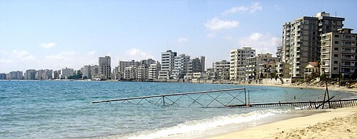 Abandoned high-rise buildings along a fenced-off beachfront in Varosha