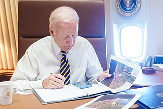Aboard Air Force One enroute to the disaster, President Biden reviews maps of damage assessments, made by FEMA and the Civil Air Patrol's geospatial team in response to the 2023 Hawaii wildfires[73]