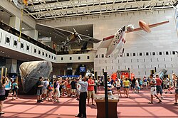 The Milestones of Flight entrance hall of the National Air and Space Museum in Washington, DC. Among the visible aircraft are Spirit of St. Louis, the Apollo 11 Command Module Columbia, SpaceShipOne, the Bell X-1, and (far right) John Glenn's Friendship 7 capsule.