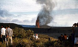 Violent strombolian eruption of scoria from a lava fountain at the Kīlauea Iki crater, 1959. Note cinder cone being constructed to the right of the fountain and the plume of scoria emanating from it.