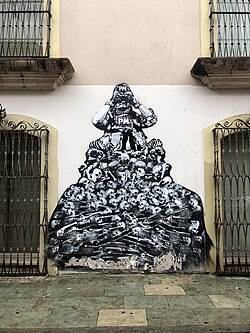 Military figure with binoculars labeled "PM" sitting atop pile of skulls and skeletons
