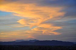 A Kármán vortex street is shown in this photo, as winds from the west blow onto clouds that have formed over the mountains in the desert. This phenomenon observed from ground level is extremely rare, as most cloud-related Kármán vortex street activity is viewed from space.