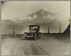 A 1919 Detroit Electric car on a promotional tour from Seattle to Mt. Rainier, with the mountain in the background.