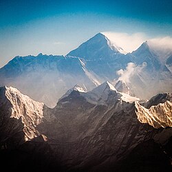 View from the south (Nepal) shows Everest rising behind the ridge connecting Nuptse and Lhotse; in the foreground are Thamserku, Kangtega, and Ama Dablam