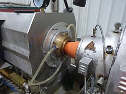 HDPE pipe during extrusion. The HDPE material is coming from the heater, into the die, then into the cooling tank. This Acu-Power conduit pipe is co-extruded - black inside with a thin orange jacket, to designate power cables.