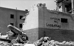 Propaganda inscription, "the work of the liberators" (opera dei liberatori), on wall of a bombed building, Rome, 1944