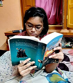 A teenage girl reading Harry Potter and the Goblet of Fire in 2023