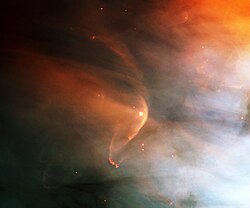 This is thought to show the solar wind from the star L.L. Orionis generating a bow shock (the bright arc).