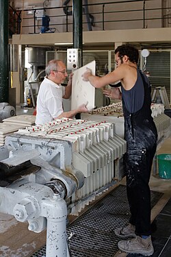 Removing a filter cake of porcelain body from a filter press