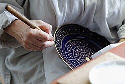Burnishing a plate's gold decoration