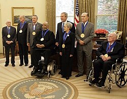 President George W. Bush stands with recipients of the 2005 National Medal of Arts on November 9, 2005, in the Oval Office. Among those recognized for their outstanding contributions to the arts were, from left: Leonard Garment, Louis Auchincloss, Paquito D'Rivera, James DePreist, Tina Ramirez, Robert Duvall, and Johnston
