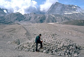 USGS scientist examines pumice blocks at the edge of a pyroclastic flow from Mount St. Helens