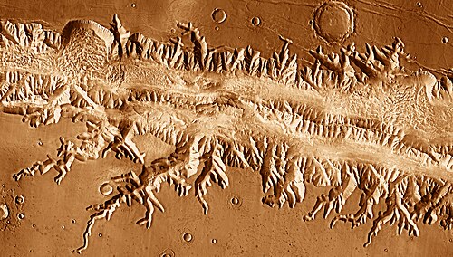 Ius Chasma image mosaic from 2001 Mars Odyssey, showing side canyons created by sapping. On the northern (upper) rim, right of center, a canyon turns 90 degrees where it encounters a graben.
