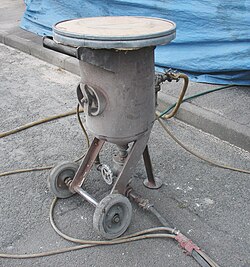 Device used for adding sand to the compressed air (top of which is a sieve for adding the sand)