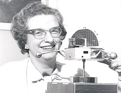 Roman with a model of the Orbiting Solar Observatory in 1962