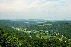 Canisteo River Valley from Pinnacle State Park, New York. The distant peaks at the same elevation represent the remnants of a peneplain that was uplifted to form the Allegheny Plateau, which is a dissected plateau in southwestern New York. In this area, the sharp relief that is seen on some of the Allegheny Plateau has been rounded by glaciation.