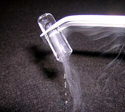 A small piece of rapidly melting solid argon shows two concurrent phase changes: the transitions from solid to liquid and from gas to liquid (shown by the white condensed water vapour).