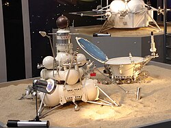 Model of the Luna sample return lander with soil sample scoop – the ascent stage is the smaller cylinder with spherical Earth-return capsule on top.