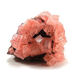 Pink cubic halite (NaCl; halide class) crystals on a nahcolite matrix (NaHCO3; a carbonate, and mineral form of sodium bicarbonate, used as baking soda).