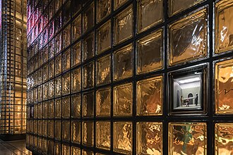 Exterior view of the illuminated facade of Maison Hermès in Tokyo, made of glass bricks.