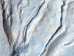 Ice sheet in Oxus Patera, a caldera in Arabia Terra. The scalloped nicks along the spines of the caldera's ridges are likely cracks caused by the expansion and contraction of ice.