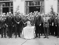 Lindbergh receiving the Harmon Trophy on December 13, 1928, at the International Civil Aeronautics Conference in Washington, D.C. He was escorted to the platform by Orville Wright, standing at Lindbergh's left.[317]