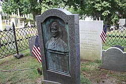 Mercy Otis Warren's gravestone is located directly behind James Warren's plaque. She is buried alongside her husband at Burial Hill.