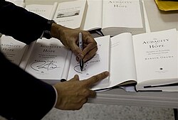 Obama signs copies of The Audacity of Hope at a town hall meeting in Elkhart, Indiana, in 2009.