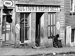 Slave trader's business on Whitehall Street Atlanta, Georgia, 1864 during the American Civil War with a Union corporal of the United States Colored Troops sitting by the door