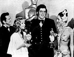 Hamlisch, at age 29, holding two of the three Oscars he won in 1974. With him are Donald O'Connor, Debbie Reynolds, and Cher.