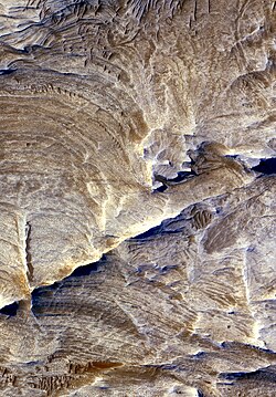 Tectonic fractures within the Candor Chasma region of Valles Marineris, Mars, retain ridge-like shapes as the surrounding bedrock erodes away.