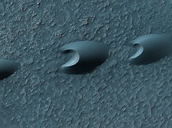 Seif and barchan dunes in the Hellespontus region on the surface of Mars. Dunes are mobile landforms formed by the transport of large volumes of sand by wind.
