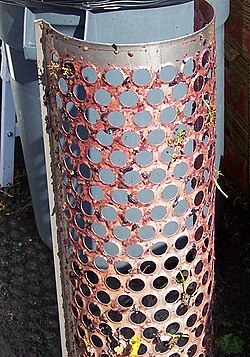Central component of a mechanical destemming. Paddles above the small circular slots rotate to remove the larger chunks of stems. Grapes are pulled off the stems and fall through the holes. Some small amount of stem particles are usually desired to be kept with the grapes for tannin structure.