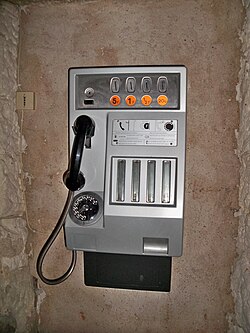 A telephone booth in France prior to the switch to the euro. Coins are Francs on the labels. It also uses the rotary dial and the 20 centimes coin, which means the device dates back to circa 1980.