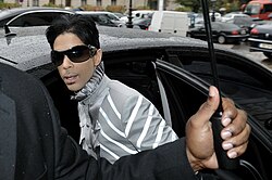 Prince with sunglasses on entering a vehicle