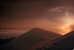 Lava flows from Mauna Loa caught by one of the International Gemini Observatory's Cloudcams, which operates 24/7 near the snow-covered summit of Maunakea (the highest point in the image).(on 27 November 2022).