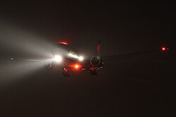 Boeing 777 with landing lights, navigation lights, and anti-collision beacon lights turned on
