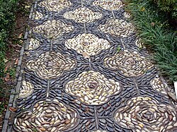 A walkway decorated with pebbles set into concrete