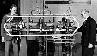 Louis Essen (right) and Jack Parry (left) standing next to the world's first caesium-133 atomic clock in 1955, at the National Physical Laboratory in west London, England.