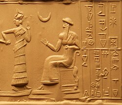 Impression of the cylinder seal of Ḫašḫamer, ensi. The seated figure is probably king Ur-Nammu, bestowing the governorship on Ḫašḫamer, who is led before him by the goddess Lamma. Nanna himself is indicated in the form of a crescent (c. 2100 BCE)[14]
