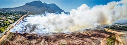 An aerial view of a controlled burn in Helderberg Nature Reserve in South Africa bordering the city of Cape Town. In South Africa controlled burns are important for maintaining the ecological health of indigenous fynbos as well as reducing the intensity of future burns.