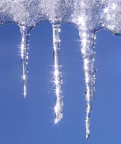 Water dripping from a slab of ice and then freezing, forming icicles