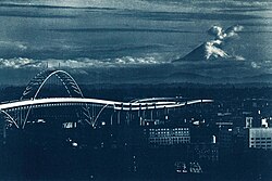 Mount St. Helens during an eruption prior to May 18, as viewed from Portland, Oregon. The Fremont Bridge is visible in the bottom left corner.