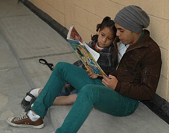 Volunteer reads to a girl at the Casa Hogar de las Niñas in Mexico City.