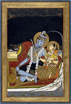 Shiva with Parvati. Shiva is depicted three-eyed, the Ganges flowing through his matted hair, wearing ornaments of serpents and a skull garland, covered in ashes, and seated on a tiger skin.