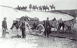 Civilian burial party, loading victims on a cart for burial