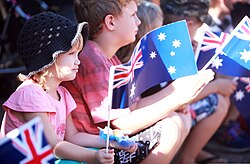 Children wave Australian flags during an Anzac Day parade in Palmerston