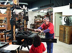 A member of staff at the International Printing Museum demonstrates printing with a 19th-century, hand-operated Columbian press.