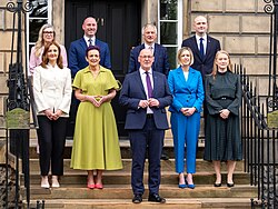 The second Swinney cabinet standing outside Bute House.