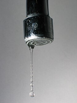 Breakup of an elongated stream of water into droplets due to surface tension.